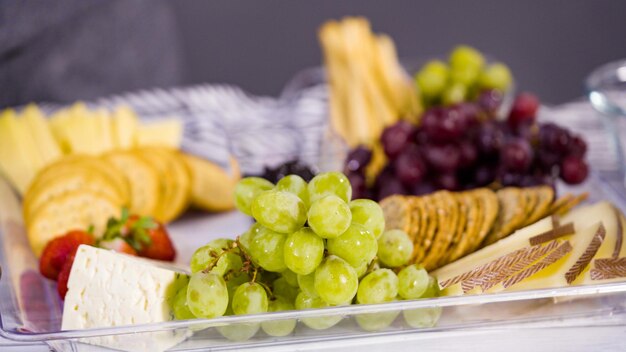 Stap voor stap. kaasplankje met vers fruit, gourmet kaas en crackers regelen.