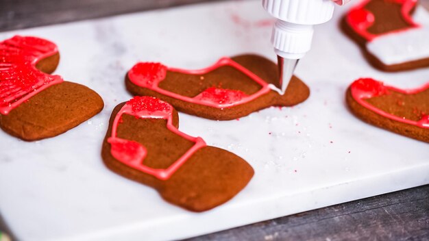 Stap voor stap. Peperkoek en suikerkoekjes versieren met royal icing voor Kerstmis.