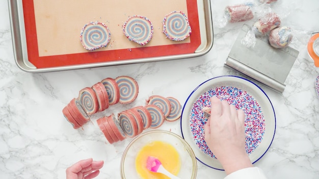 Stap voor stap. Plat leggen. Rollende randen van rode, witte en blauwe pinwheel-suikerkoekjes in hagelslag.