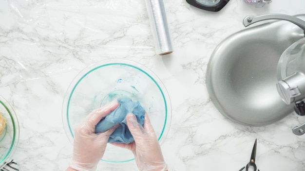 Stap voor stap. Plat leggen. Voedselkleuring in het koekjesdeeg mengen om rode, witte en blauwe pinwheel-suikerkoekjes te bakken.