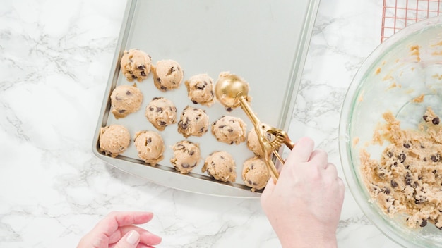 Stap voor stap. Plat leggen. Zelfgemaakte chocoladekoekjes met metalen deeglepel op de bakplaat scheppen.