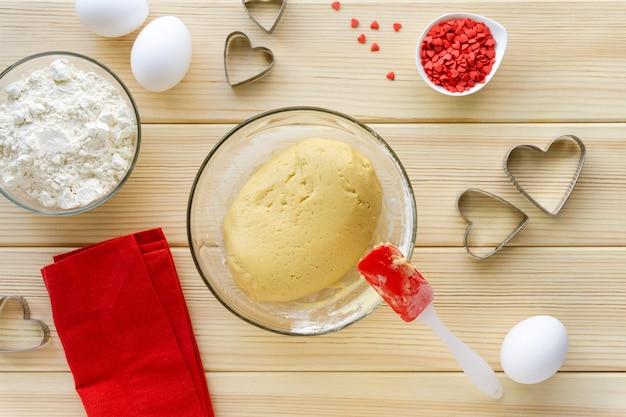 Stap voor stap recept voor het maken van koekjes voor Valentijnsdag. Afgewerkt zandkoekdeeg in een glazen kom