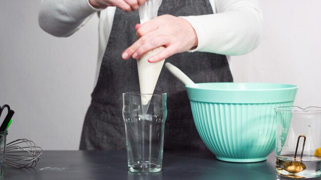 Stap voor stap. Royal icing in de spuitzak gieten om suikerkoekjes te versieren.