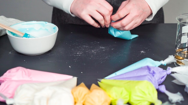 Stap voor stap. Royal icing in de spuitzak gieten om suikerkoekjes te versieren.