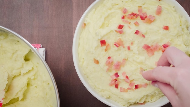 Stap voor stap. Serveerschaal met Amerikaanse stijl romige aardappelpuree gegarneerd met spek en bieslook.