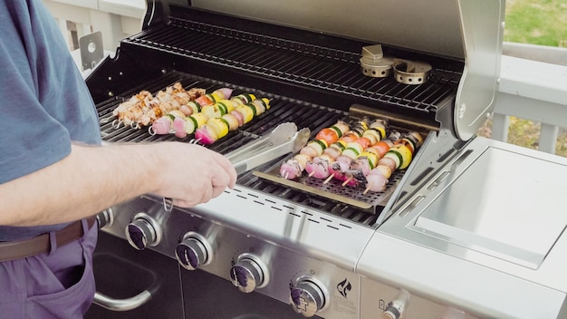 Stap voor stap. Stap voor stap. Vegetarische spiesjes en kipkebabs grillen op een buitengasgrill.