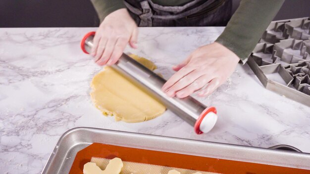 Stap voor stap. Suikerkoekdeeg uitrollen om kerstkoekjes te bakken.