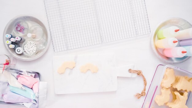 Stap voor stap. Suikerkoekjes in unocrn-vorm versieren met royal icing voor een verjaardagsfeestje voor kleine meisjes.