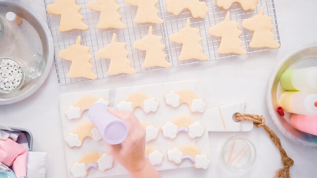 Stap voor stap. Suikerkoekjes in unocrn-vorm versieren met royal icing voor een verjaardagsfeestje voor kleine meisjes.