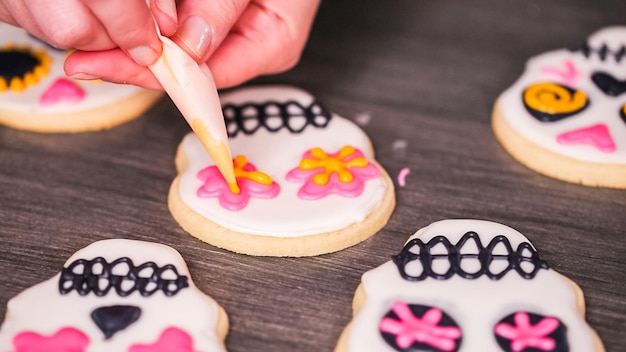 Stap voor stap. Suikerschedelkoekjes versieren met verschillende kleuren royal icing.