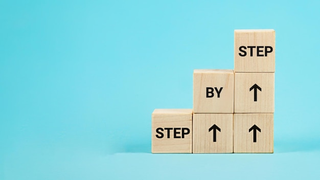 Stap voor stap tekst Het woord stap voor stap op houten kubussen Prestatie of vooruitgang in zakelijke carrière