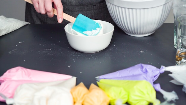 Stap voor stap. Voedselkleuring mengen met de royal icing om suikerkoekjes te versieren.