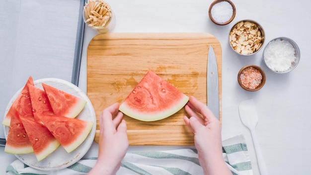 Stap voor stap. Watermeloen in blokjes snijden voor het bereiden van met chocolade bedekte watermeloenbites.