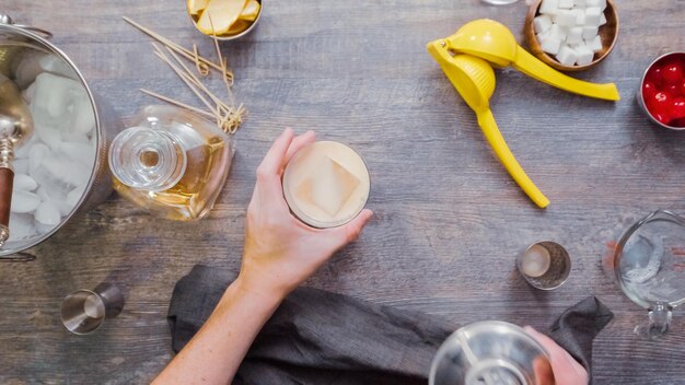 Stap voor stap. Whisky zure cocktail voorbereiden in de thuisbar.