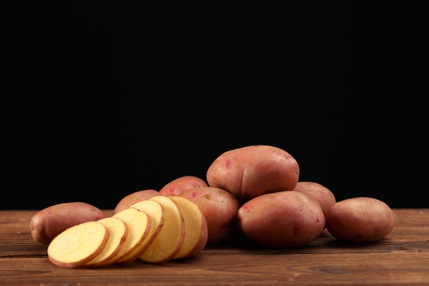 Foto stapel aardappelen liggend op houten planken