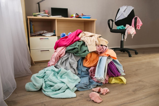 Foto stapel achteloos verspreide kleding op de vloer