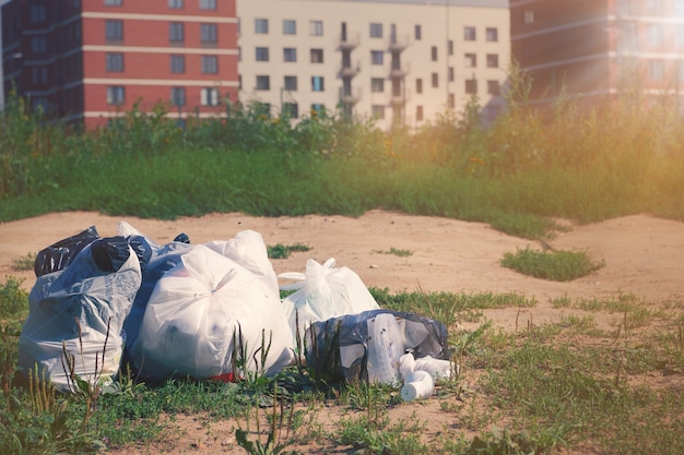 Stapel afvalpakketten op een grond tegen op wazig multi-appartementenhuis. Afval plastic. Vuilnisrecycling en afvalverwijdering probleem concept.