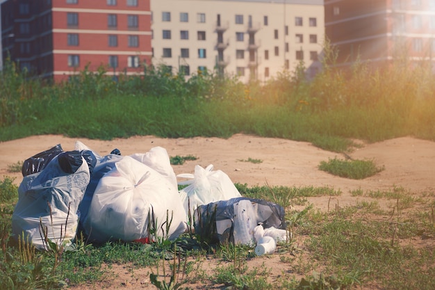 Stapel afvalpakketten op een grond tegen op wazig multi-appartementenhuis. afval plastic. vuilnisrecycling en afvalverwijdering probleem concept.