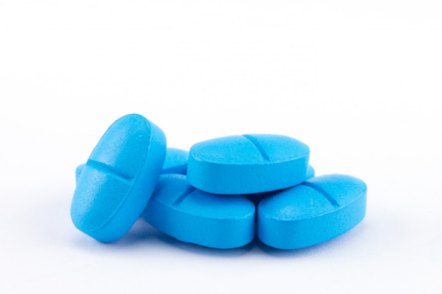 stapel blauwe tabletten van geneeskunde op wit