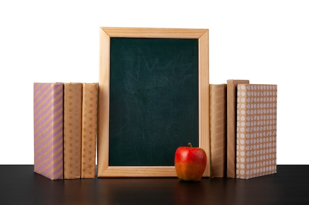 Stapel boeken en appel op tafelblad tegen witte achtergrond