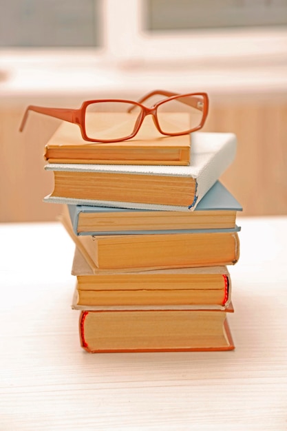 Stapel boeken en brillen erop close-up