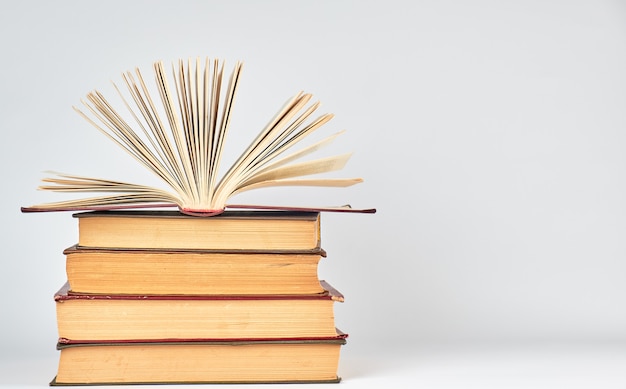 Stapel boeken en een open boek met gele pagina's