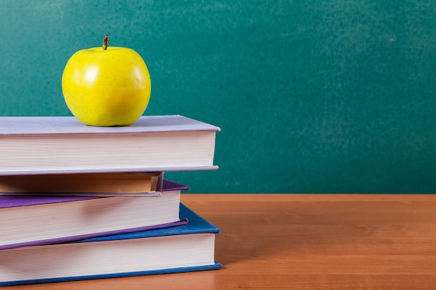 Stapel boeken en groene appel, onderwijs en leerachtergrond