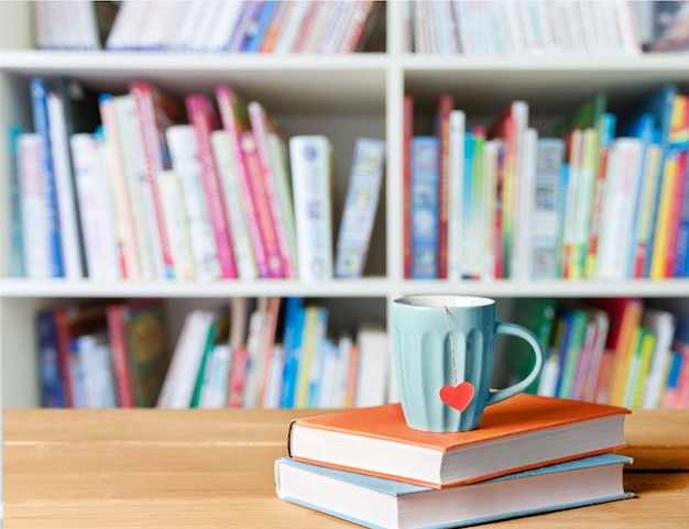 Stapel boeken met koffiekopje op houten tafel