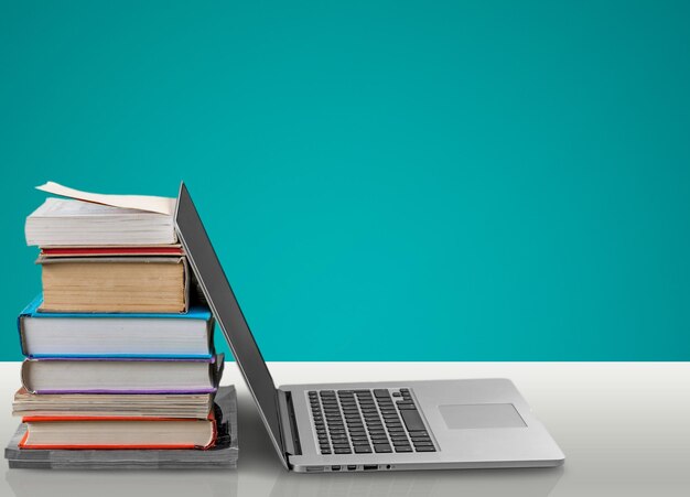 Stapel boeken met laptop op tafel