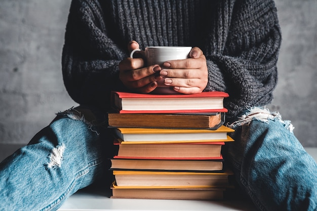 Stapel boeken met mok bovenop voor het boek van de vrouwenlezing