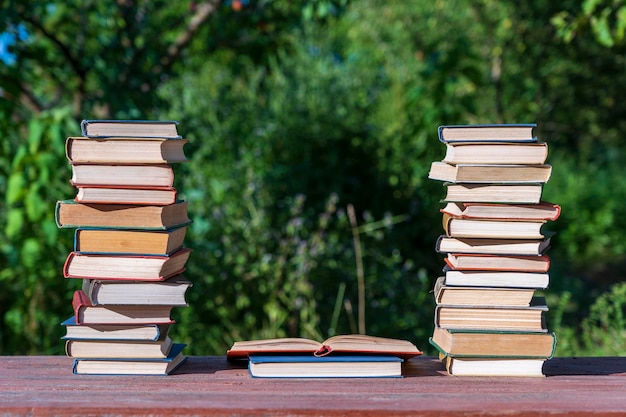 Stapel boeken op een houten tafel tegen de achtergrond van de natuur in de buitenlucht