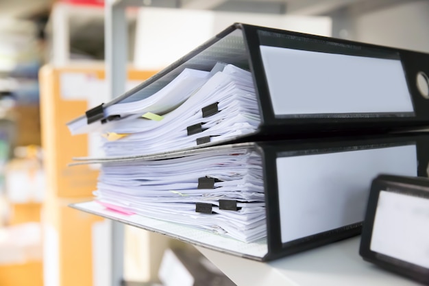 Stapel documenten met zwarte clips in mappen stapelen zich op.