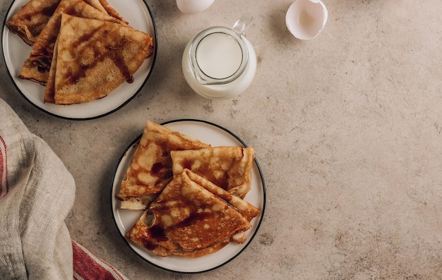 Stapel dunne pannenkoeken traditioneel voor de Russische pannenkoekweek Zelfgemaakte pannenkoeken met duindoornjam en melk voor het ontbijt Bovenaanzicht