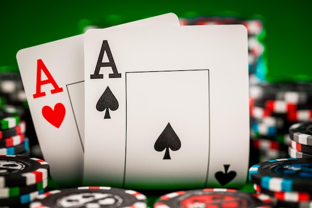 Stapel fiches en twee azen op de tafel op het groene laken - pokerspelconcept