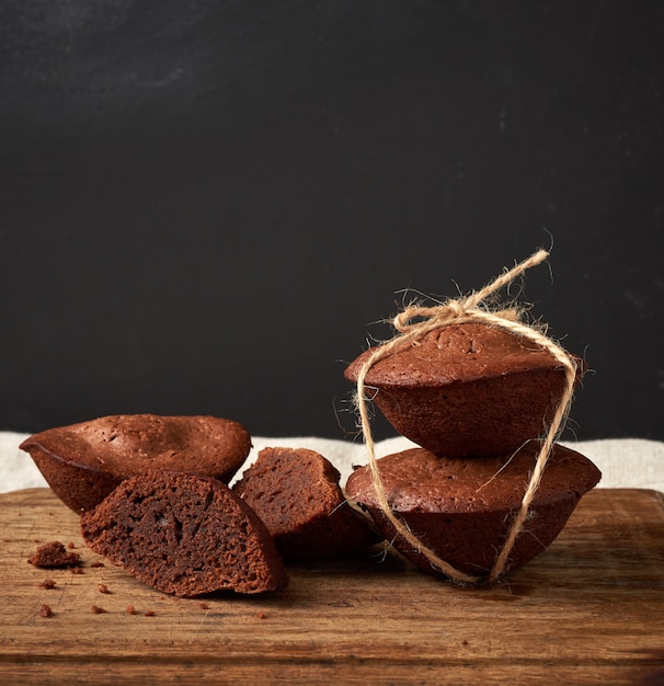 Stapel gebakken brownie ronde cakes vastgebonden met een touw op een bruin houten bord