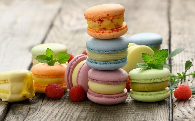 Stapel gebakken veelkleurige macarons en verschillende smaken op een grijze houten tafel, heerlijk dessert, close-up