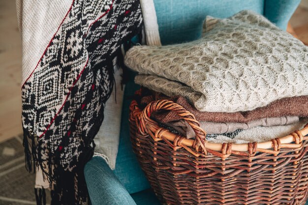 Foto stapel gebreide warme kleren op een rieten mand