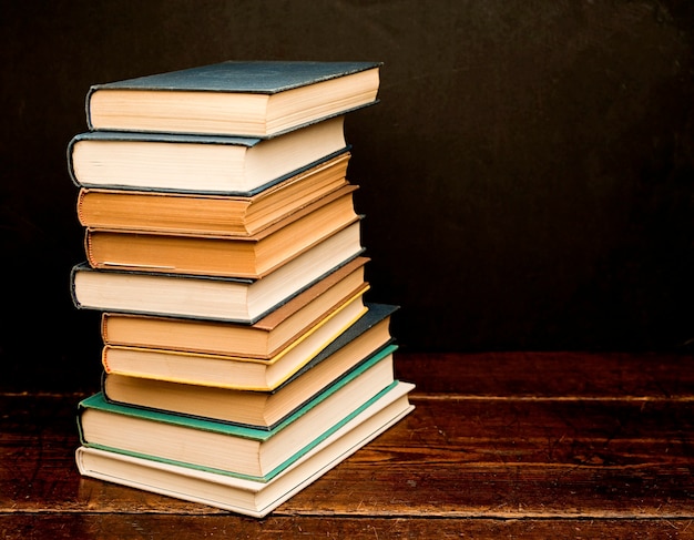 Stapel gekleurde boeken op oude houten plank