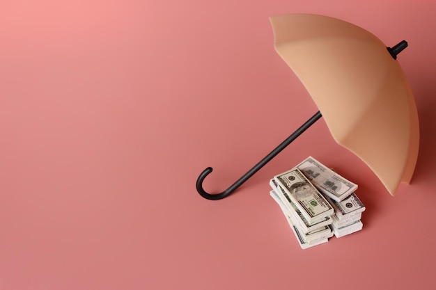 Stapel geld en paraplu voor bescherming met kopieerruimte Financieel veiligheids- en investeringsconcept