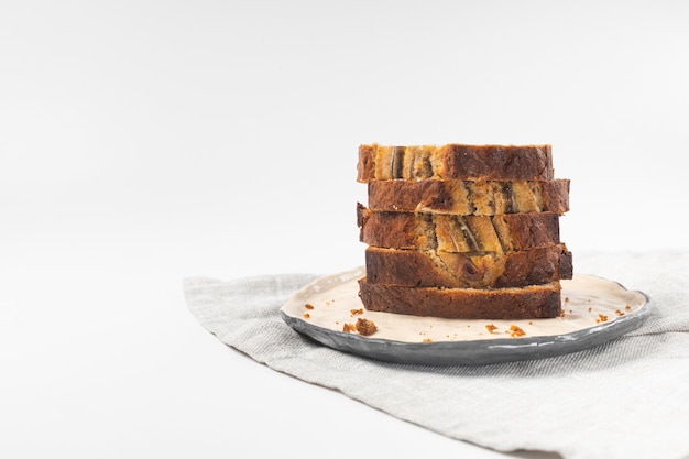 Stapel gesneden verse sneetjes bananenbrood op witte achtergrond