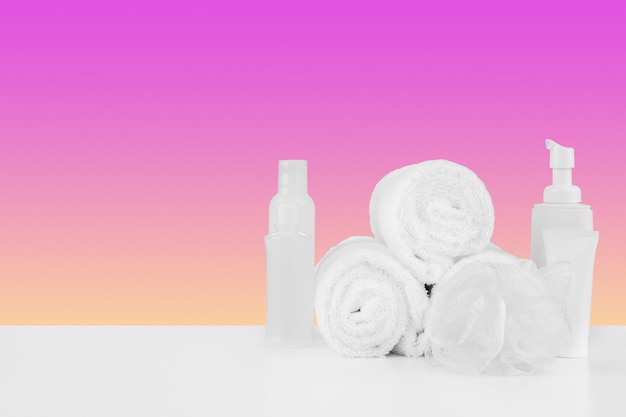 Stapel handdoekenflessen met shampoo op witte tafel