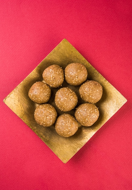 Stapel handgemaakte Tilgul Laddu of Til Gul Laddoo samengesteld uit rietsuiker of gud en sesamzaadjes voor Makar Sankranti festival, geserveerd in een kom. geselecteerde focus