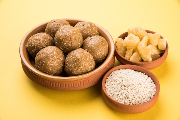 Stapel handgemaakte tilgul laddu of til gul laddoo samengesteld uit rietsuiker of gud en sesamzaadjes voor makar sankranti festival, geserveerd in een kom. geselecteerde focus