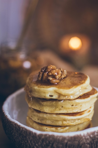 Stapel heerlijke pannenkoeken met honing, noten op houten achtergrond