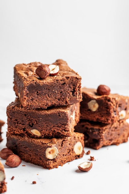 Stapel heerlijke stukjes brownie met hazelnoten op marmeren achtergrond met kopieerruimte close-up