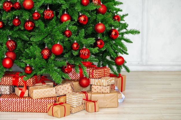 Stapel ingepakte cadeautjes onder kerstboom