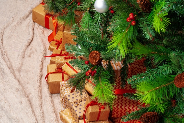 Stapel ingepakte cadeautjes onder kerstboom