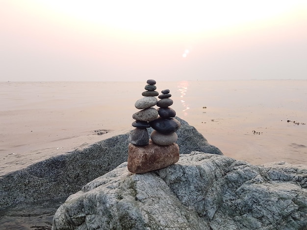 Stapel kiezels op het strand tegen de hemel tijdens de zonsondergang