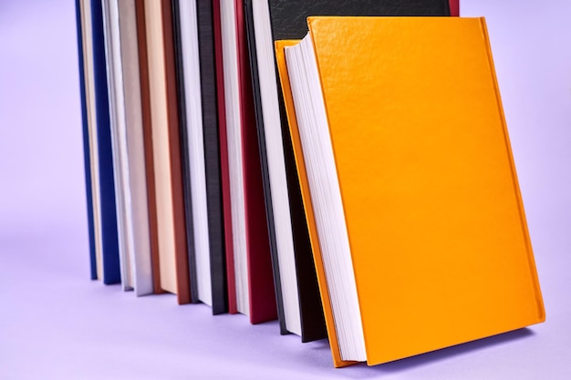 Stapel kleurrijke boeken op paarse achtergrond