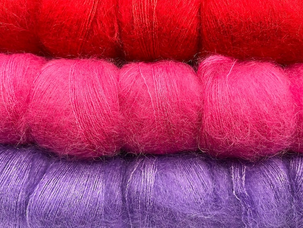 Foto stapel kleurrijke pluizige strengen voor breien en haken rood roze en violet garen